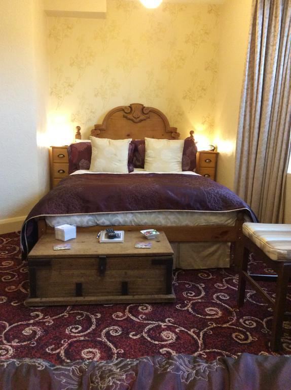Double room with wooden headboard and chest at Kays Cottage
