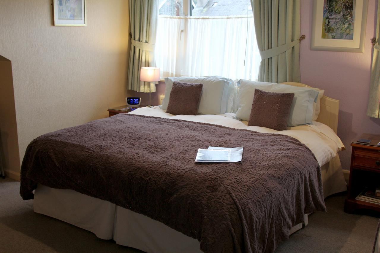 Double room with lilac curtains at Kays Cottage